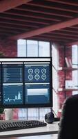 Vertical Monitor showcases business trends and targeted marketing development, SEO tools and analytics in an empty loft apartment with a spacious modern interior and a minimalist desk setup. video