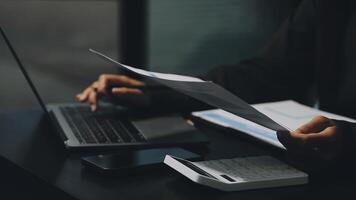 A person is working on a laptop and a paper video