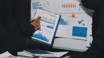 Business people looking at graphs and papers on a board video