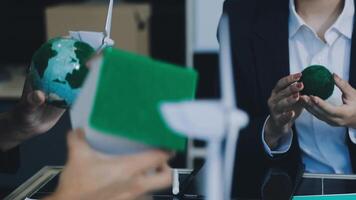 Business people holding green objects in front of a table video