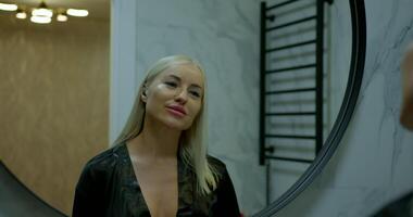 In a modern bathroom adorned with elegant fixtures a girl enjoys her time by dancing and singing along to her music while looking into the mirror. Her cheerful energy fills the space with joy video