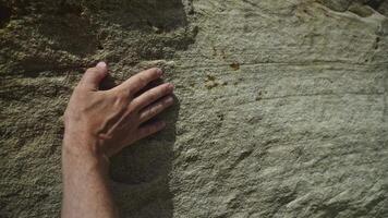 Male hand touching rough sandstone texture. Natural stone surface inspiring architects and designers with organic patterns and earthy materials. video