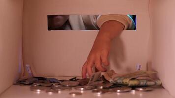 view from inside the box, the girl takes money out of the piggy bank, a coin video