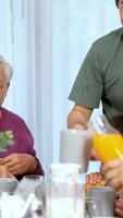 An Asian family shares a joyful breakfast, highlighting intergenerational bonding in a bright, cozy dining room video