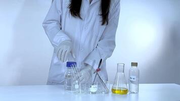 A scientist conducts a potassium carbonate experiment, mixing chemicals in a lab with controlled lighting and precise movements video