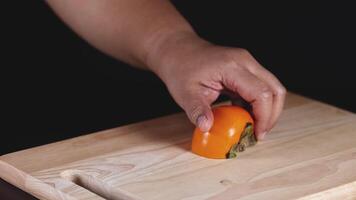 Hands skillfully slicing a ripe persimmon video