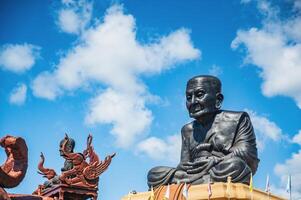 A statue of a buddha sitting on top of a large statue photo