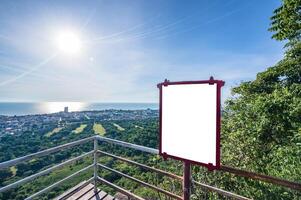 Blank billboard on the top of a hill with a view of the city photo