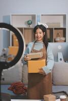 A woman in an apron is holding a box photo