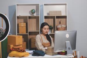 A woman sitting at a desk with boxes and a computer photo
