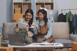 Two young girls sitting on a couch with a laptop photo