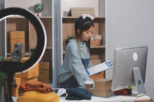 A woman is working on a computer in front of a desk photo