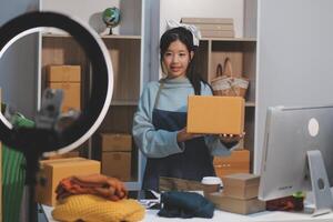A woman holding a box in front of a computer photo