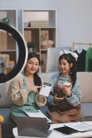 Two women sitting on a couch with a laptop photo
