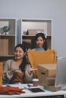 Two women sitting at a desk with boxes photo