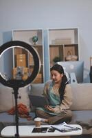 A woman sitting on a couch with a laptop photo