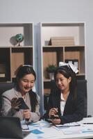 Two women in business attire sitting at a table photo