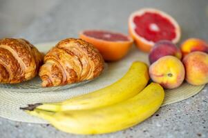 A table with fruit and croissants on it photo