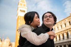 Girl on her lover's back, they enjoy walking around Venice looking into each other's eyes photo