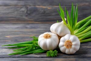 Fresh garlic bulbs and green onions resting on a dark wooden table photo