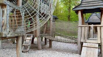 A Unique and Engaging Childrens Playground Featuring Various Wooden Structures and Climbing Nets photo