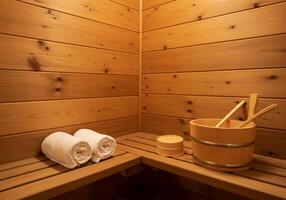 A wooden sauna room with a bucket and two towels photo