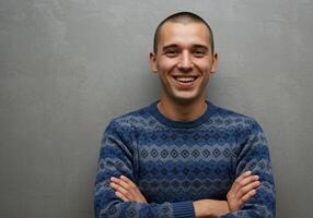 A man in a blue sweater is smiling photo