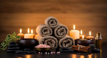 Spa concept with candles and towels on wooden background photo