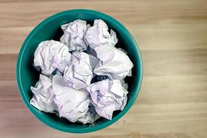 crumpled paper ball in trash can, paper waste. trash bin in office with crumple paper ball, work hard ideas concept photo