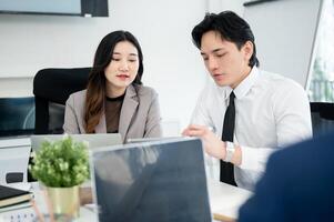 Male office worker is pointing stylus at tablet showing business data to female coworker in meeting. photo