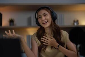 Remote Work and Digital Communication. Young woman smiling during an online meeting with headphones. photo