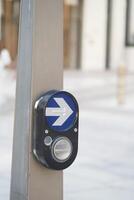Button for pedestrian crossing in urban setting photo