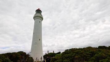 Panoramic views of a lighthouse and lush coastline under cloudy skies at Aireys Inlet, Victoria, Australia video