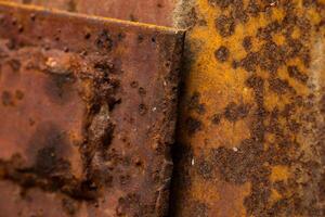 Close-up of heavily rusted metal surface with geometric patterns. photo