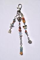 Beautiful handmade brown and blue colored beads bag charm isolated on vertical white background. photo