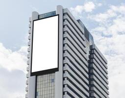 Mock up white vertical large LED display billboard on tower building with blue sky background . Clipping path for mockup photo