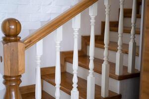 A wooden, staircase with, a railing will lead to the top photo