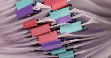 sheets of paper are connected by multicolored metal clips, stacked sheets of paper for documents are joined together photo