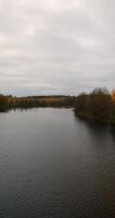 autumn landscape in cloudy weather with a lake and deciduous trees photo