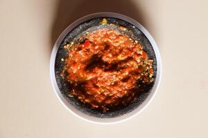 Red chili tomato and shrimp paste sambal on plate top view photo