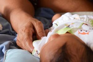 Asian mother caring for baby during diaper change photo