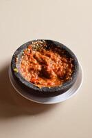 Red chili tomato and shrimp paste sauce on cream background photo