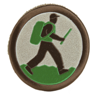 Circular embroidered patch features hiker with backpack and walking stick, set against green and brown background. design is simple and symbolic, representing outdoor activities and adventure png