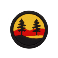 Circular patch design features two silhouetted pine trees against vibrant yellow and red background, evoking sunset or sunrise scene. patch has textured, embroidered appearance png