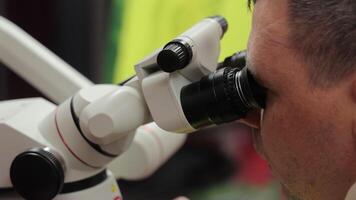 Scientist or Technician Observes Through Precision Microscope During Laboratory Examination Procedure video