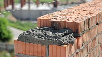 Close-Up of Mason Laying Clay Bricks with Cement Mortar, Wearing Gloves and Guiding with String Line video