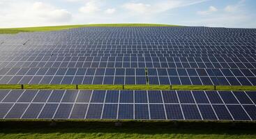 A wide expanse of solar panels stretches across a green field photo