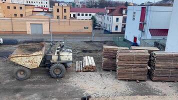 A construction site displaying a large dump truck, along with stacks of logs neatly arranged photo