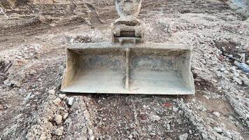 An Excavator Bucket Featured on a Busy Construction Site, Ready for Grading and Digging Work photo