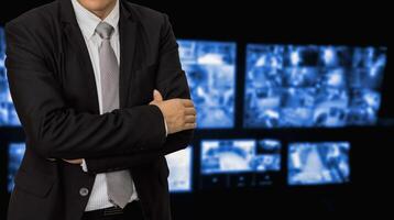 A man in a suit and tie standing in front of a screen photo